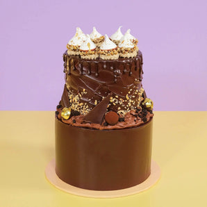 2 Tier Ferrero & Chocolate Cake with rich chocolate icing, hazelnut truffles, meringues, and gold leaf decoration by Crumbs & Doilies